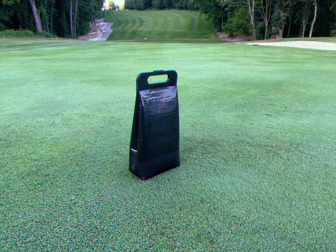 Cooler bag on the ground on a golf course with tree lined fairway