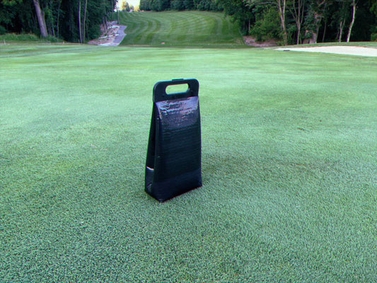 Cooler bag on the ground on a golf course with tree lined fairway