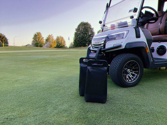 Two cooler bags in front of a golf cart on a golf course